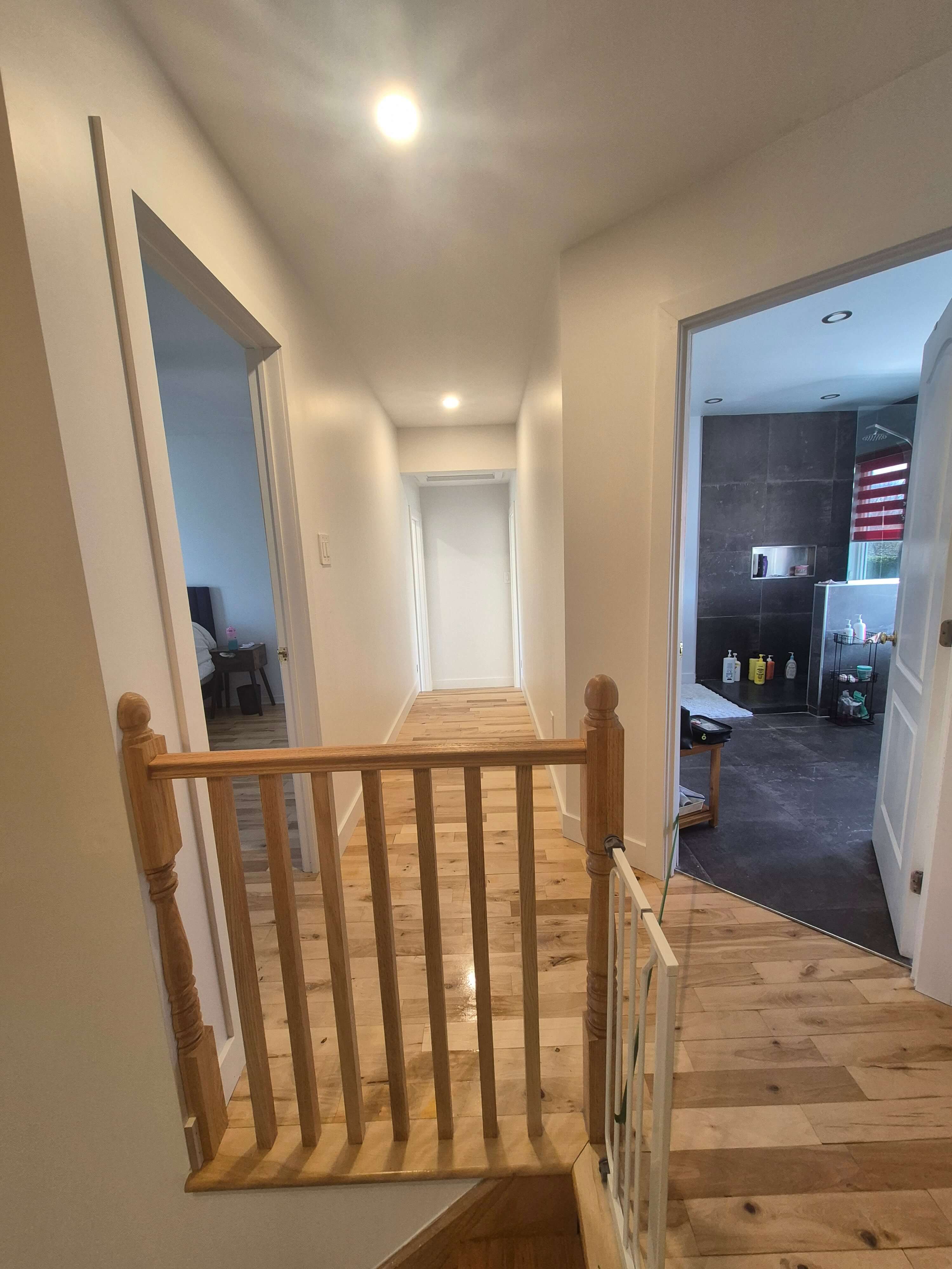 Couloir rénové avec plancher de bois et finition blanche